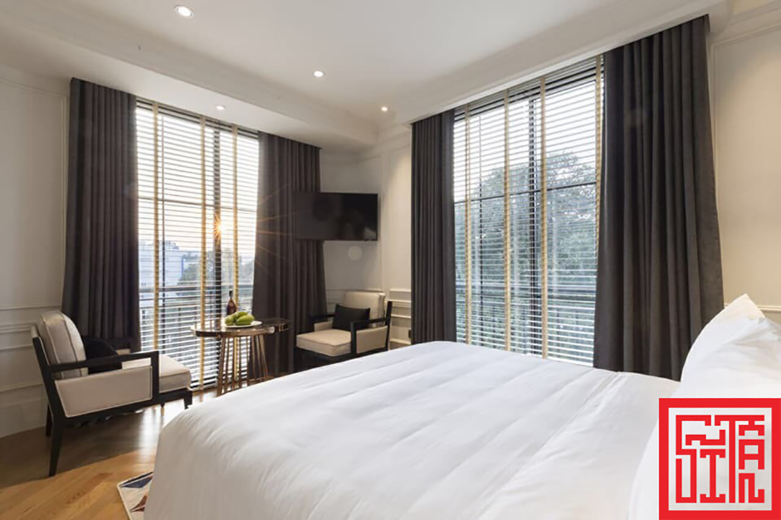 Phòng ngủ khách sạn Bach Suites Saigon với thiết kế ánh sáng tự nhiên.