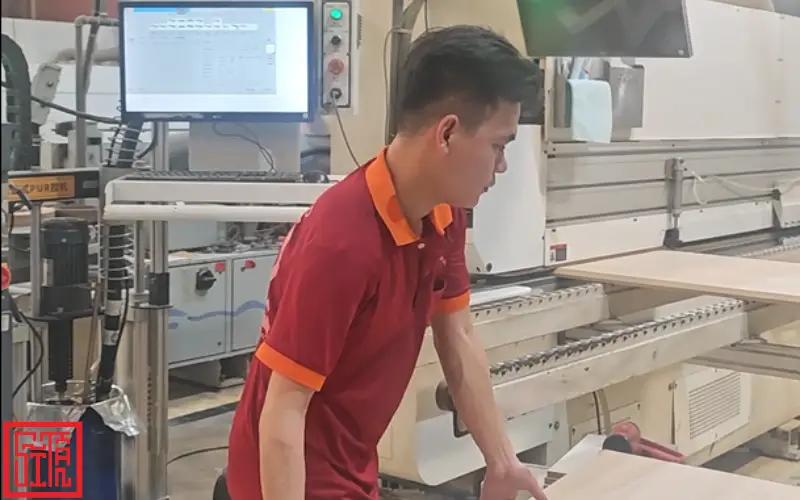 Thợ thi công nội thất Sĩ Tấn dán cạnh MDF tại xưởng sản xuất.